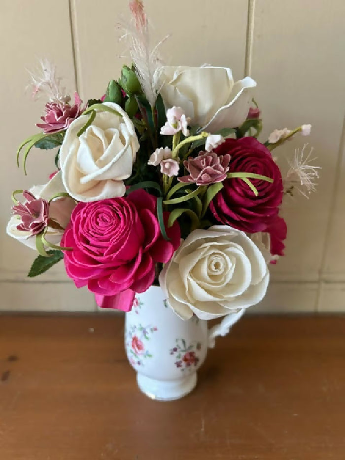 White mug with pink flowers on it, green and pink filler, bright pink and white Sola Wood flowers.